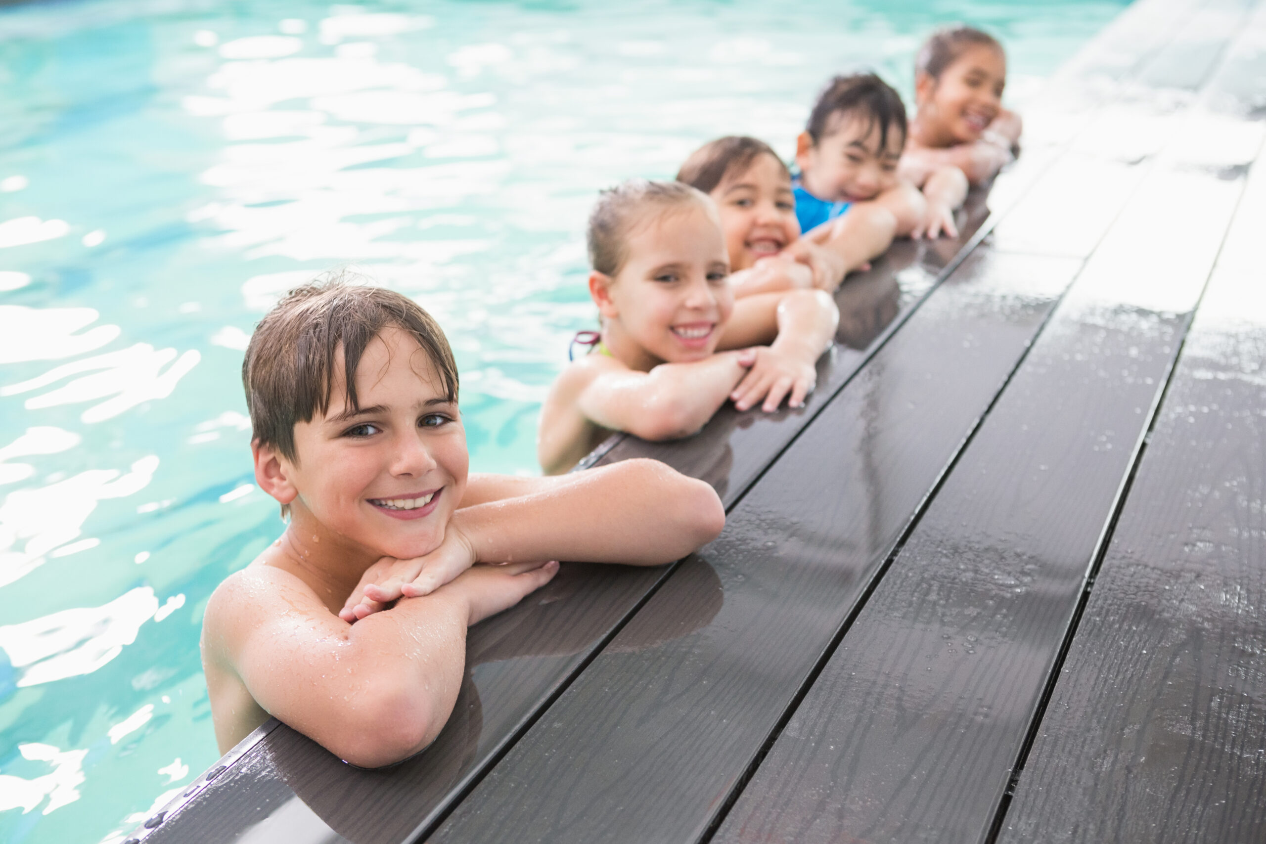 Cute swimming class in the pool at the leisure center